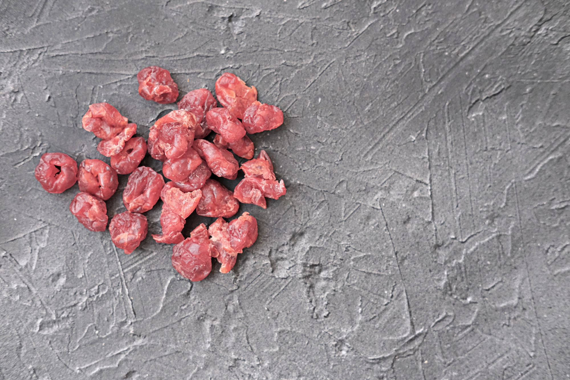 freeze dried cranberries on grey background.